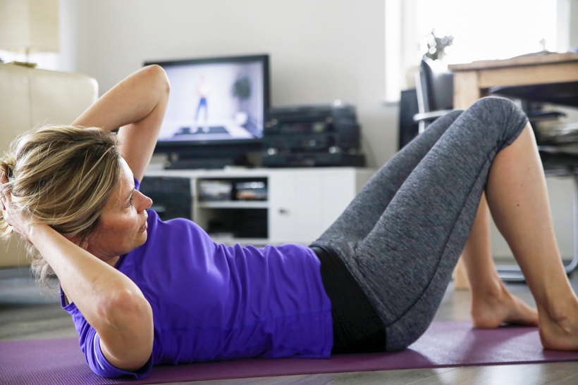 Vrouw doet oefeningen thuis
